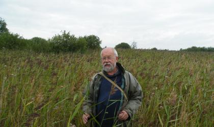 Jan Meijer verzamelt insectenvallen in riet